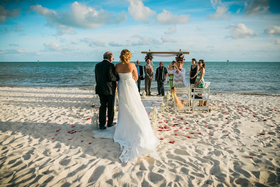 A key west wedding ceremony on the beach with a bride and groom.