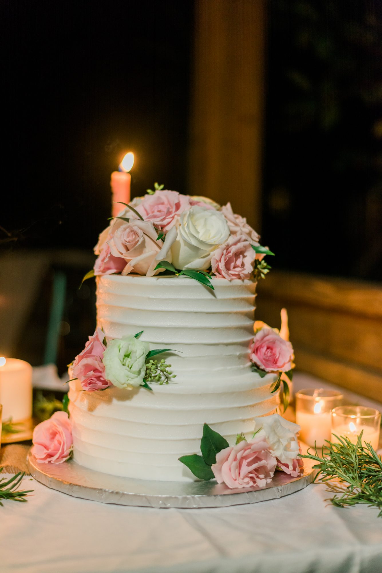 A sailing themed wedding cake with pink and white flowers on top, perfect for a Key West wedding.