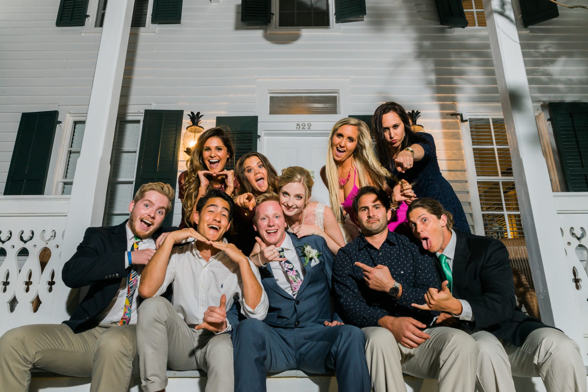 A group of people posing for a photo in front of a house during a sailing themed key west wedding.