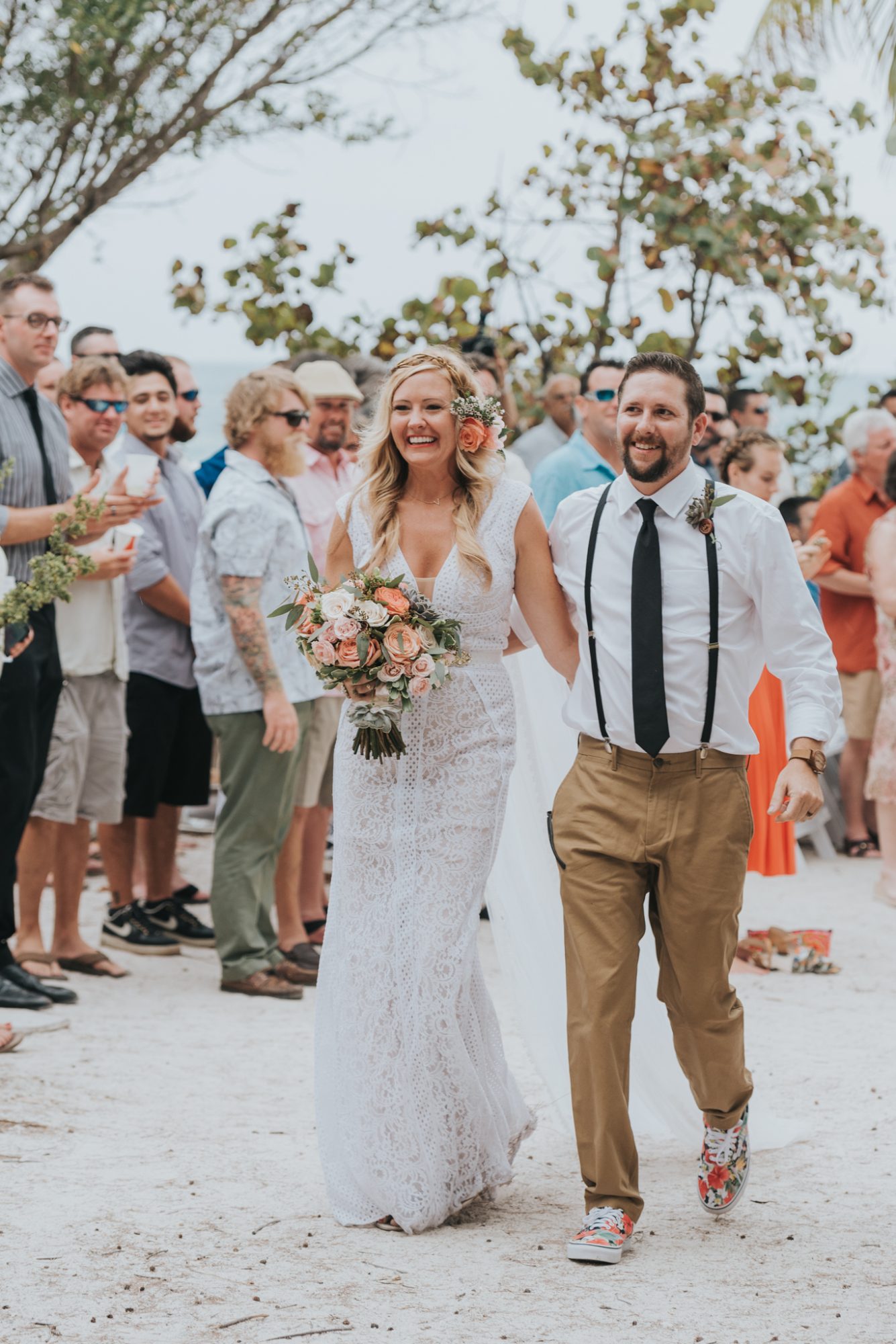Amy and Teddy, a bride and groom, walking down the beach after their Key West wedding ceremony.