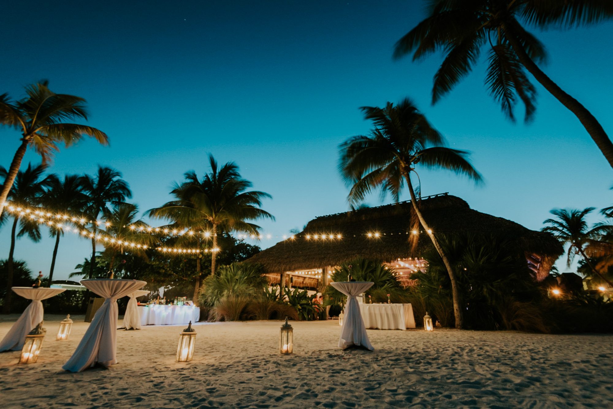 A beach wedding at dusk with candles on the sand, photographed by an Islamorada Wedding Photographer at Postcard Inn.