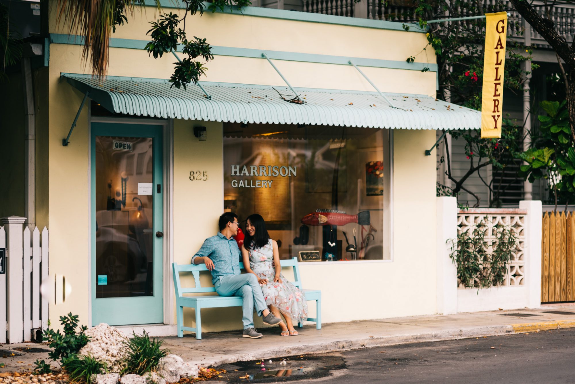 Xiao and Ying's sunset engagement session in Key West, FL captured them sitting on a bench in front of a store.