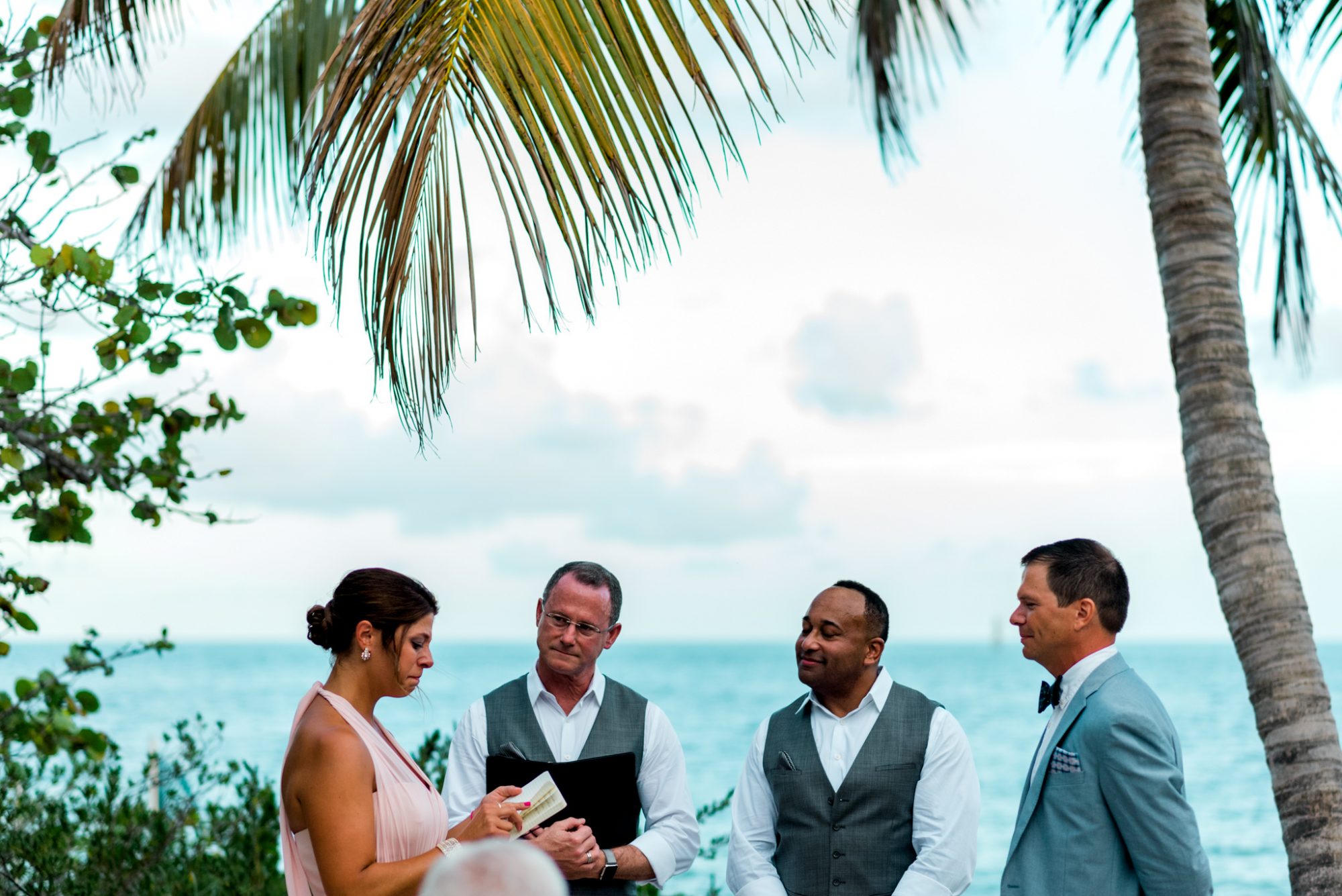 Freya and Jamie having a Key West wedding under a palm tree.