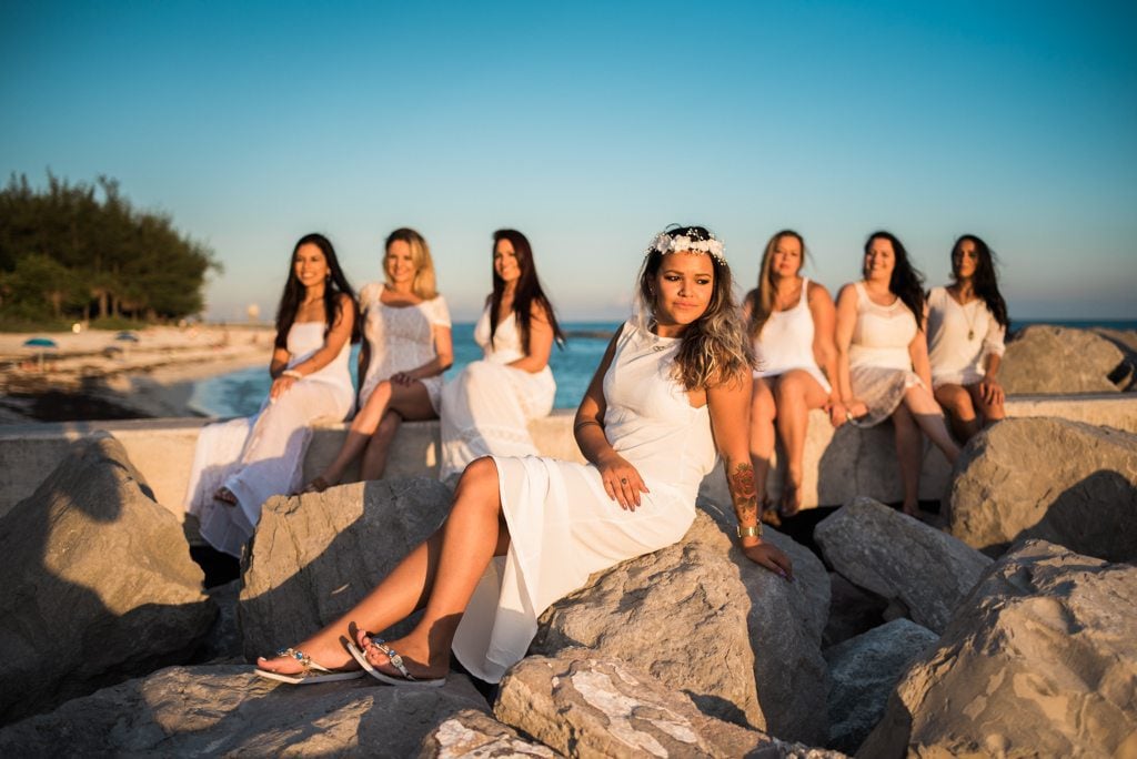Bachelorette party bridesmaids posing on rocks at the beach during a Key West weekend getaway.