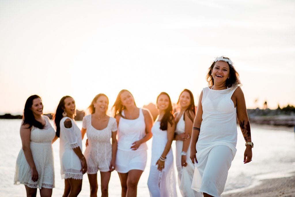 A group of bridesmaids in white dresses on the beach during a Bachelorette Party Weekend in Key West.