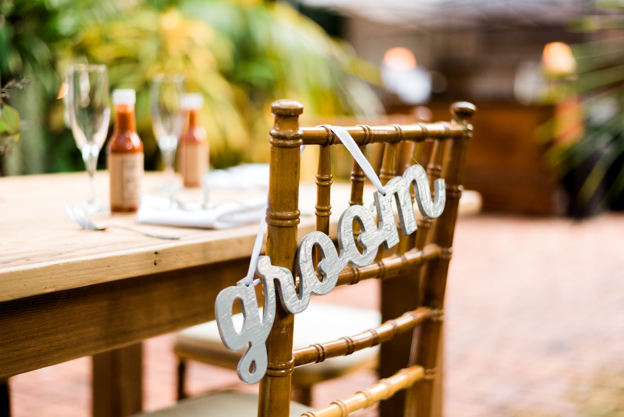 A wooden chair with the word groom on it, perfect for a Key West Audubon House and Gardens wedding.
