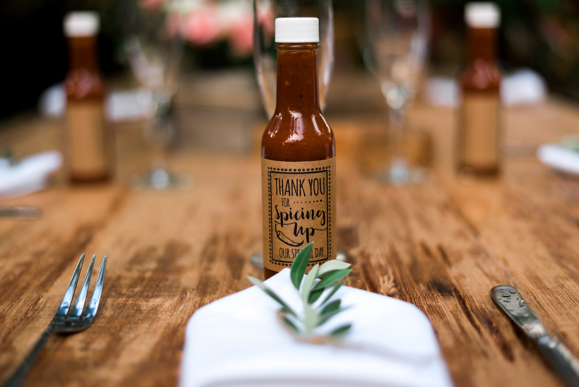A bottle of hot sauce sits on a Key West wooden table.