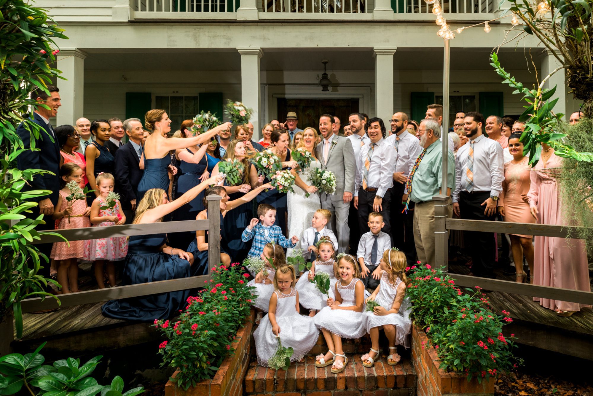 A Key West wedding party posing in front of the Audubon House and Gardens.