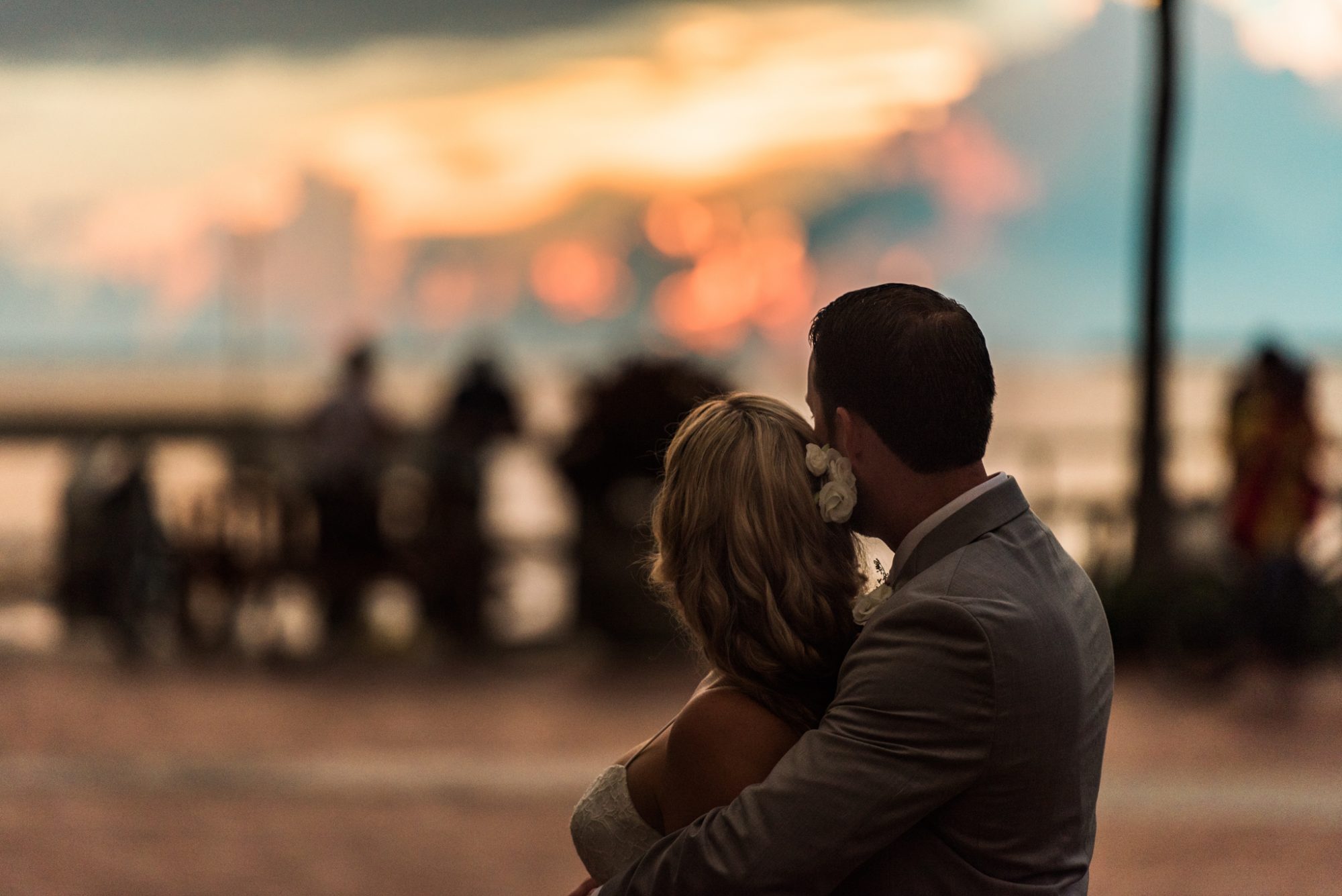 A Key West bride and groom embrace in front of a sunset at their Audubon House and Gardens wedding.