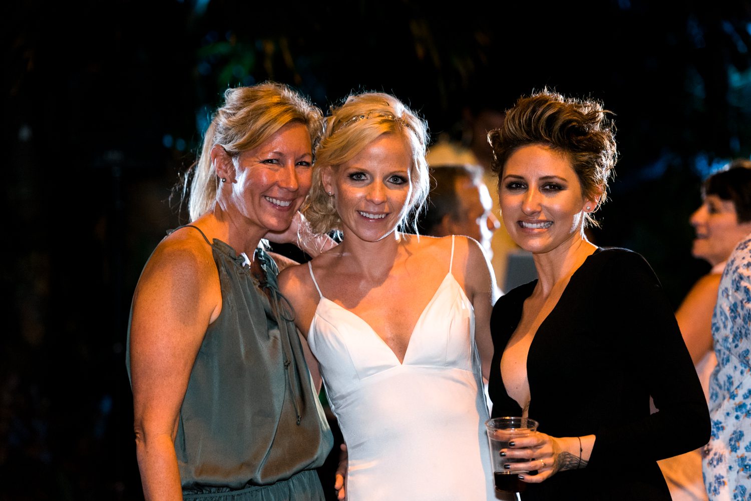 Three women posing for a photo at a Key West garden club wedding party.