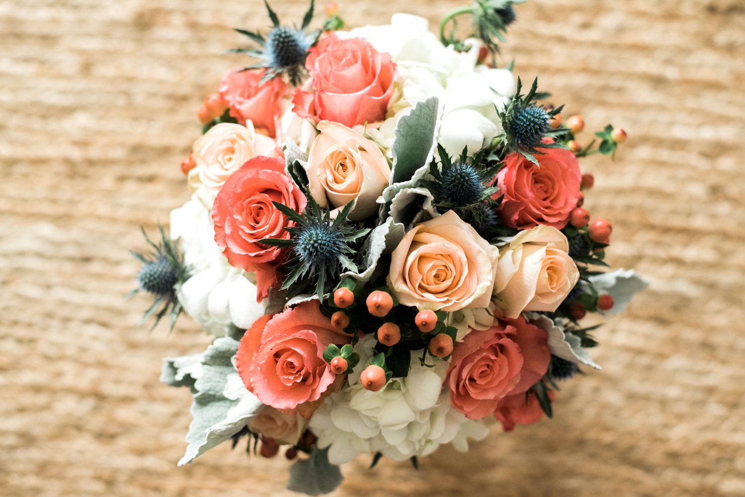 A beautiful bouquet of peach roses and thistle on a rug, perfect for a romantic Florida Keys wedding at the Postcard Inn.