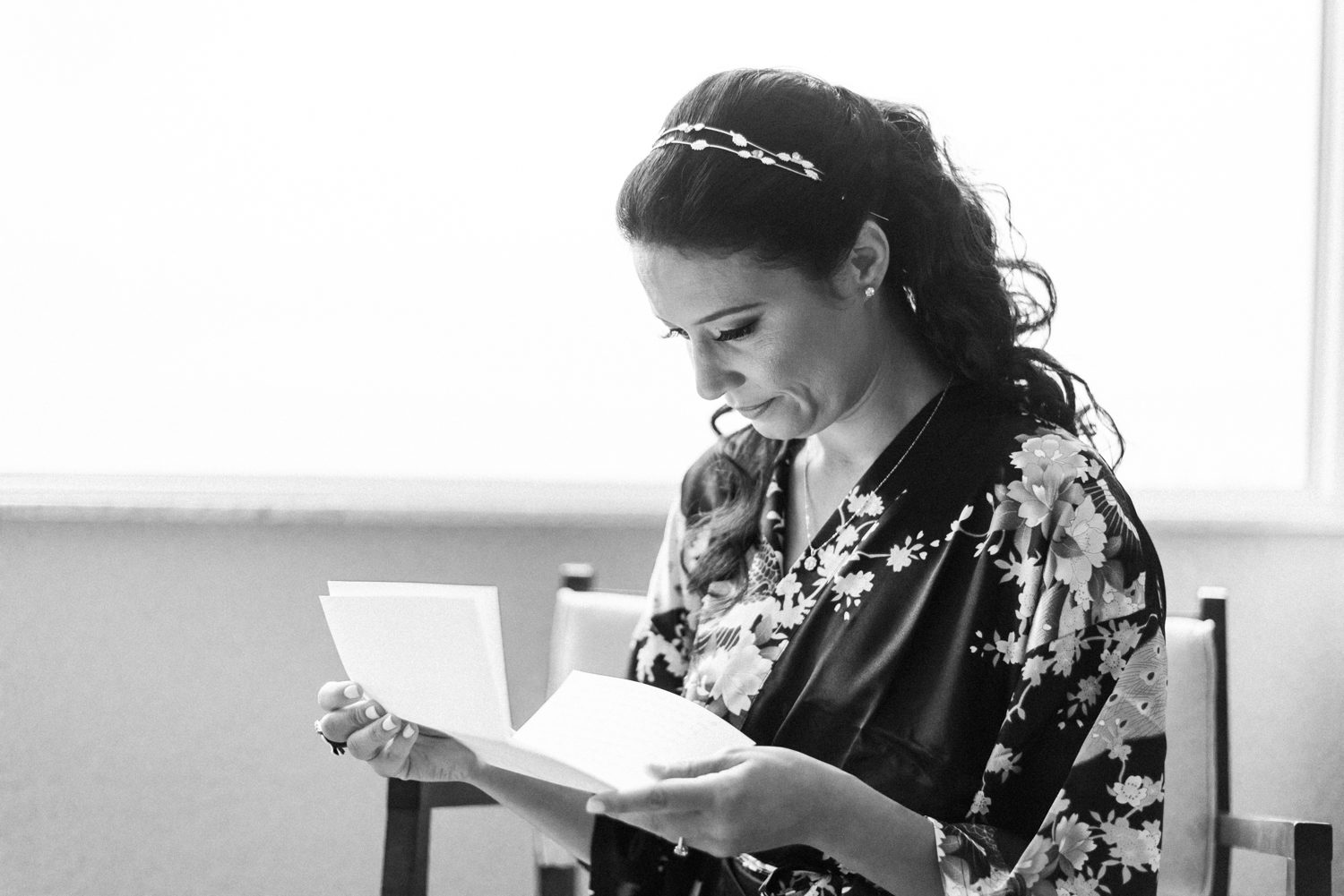 A woman sitting in a chair reading a book.