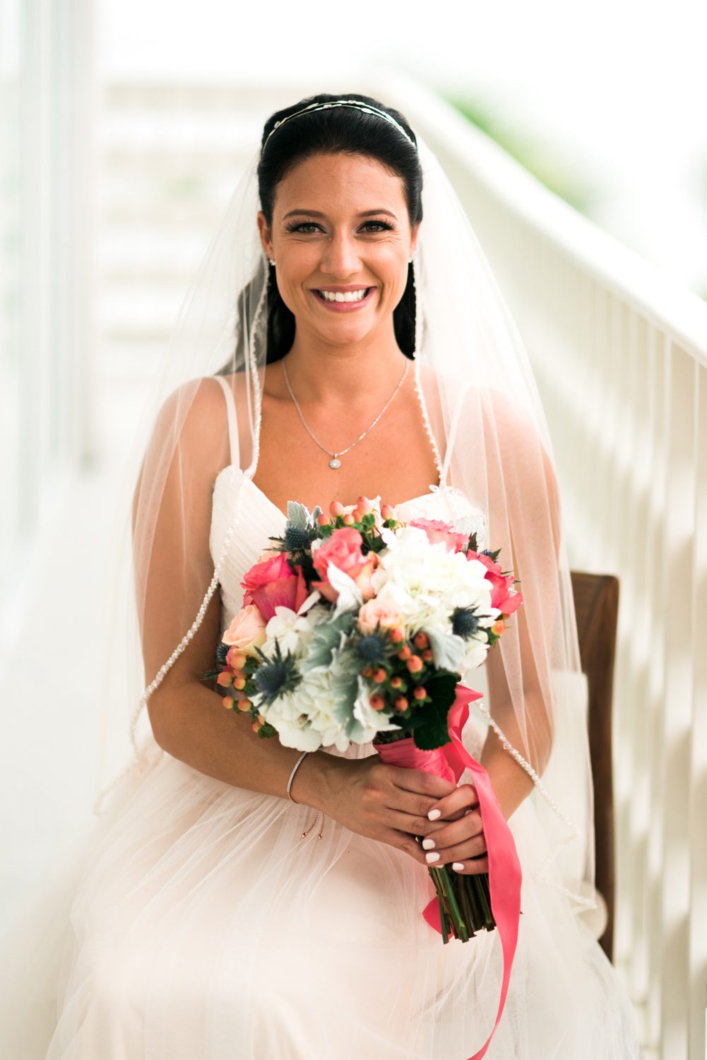 A bride holding a bouquet on a balcony at the Florida Keys Wedding Postcard Inn.