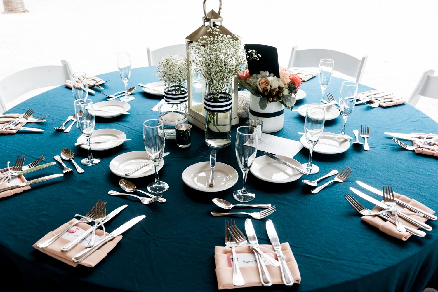 A Florida Keys wedding table setting at the Postcard Inn with blue accents and silverware, adorned with napkins.