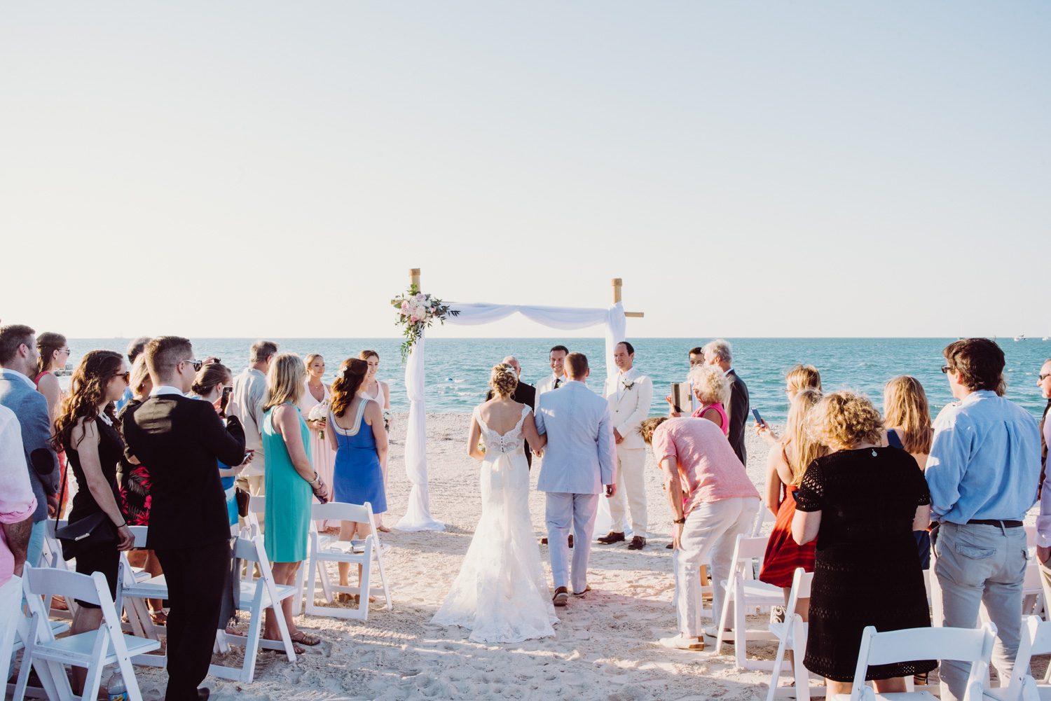 A sunset beach wedding ceremony with a bride and groom in Key West.