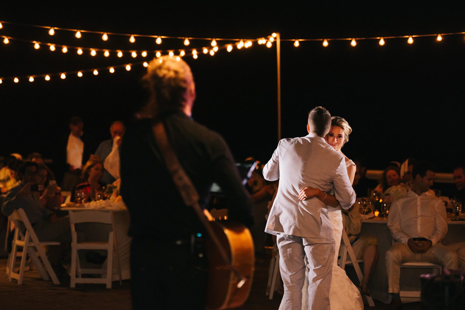 A bride and groom sharing their first dance at a romantic sunset key wedding.