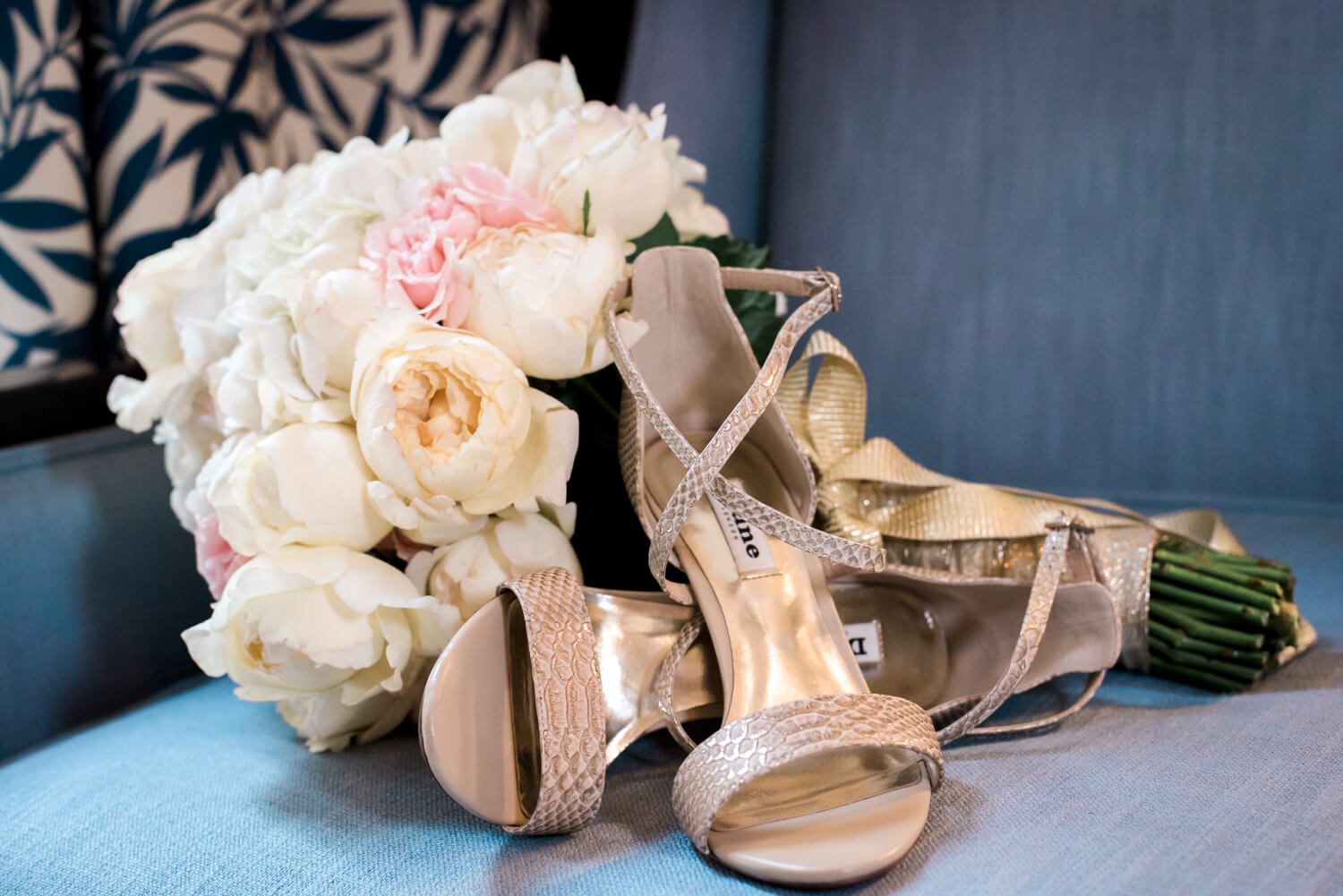 A Key West Wedding Photographer captures Wendy & Michael with a pair of shoes and a bouquet of flowers on a blue chair.