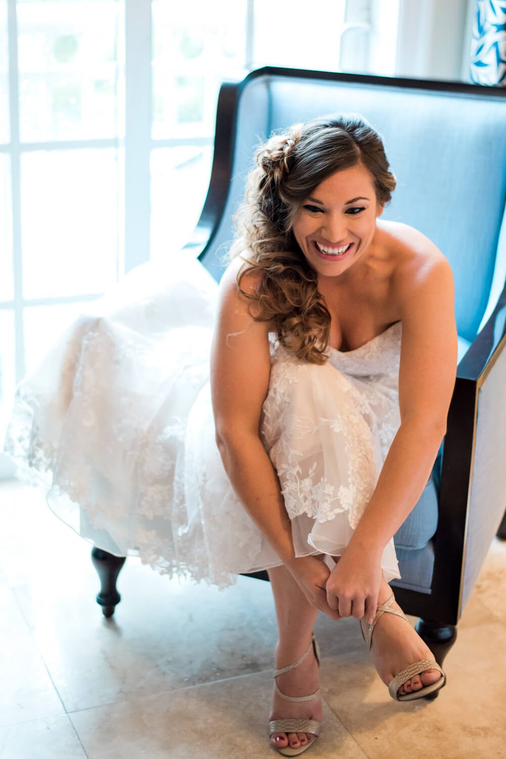 A bride sitting on a chair in her wedding dress captured by Key West Wedding Photographer - Freas Photography.