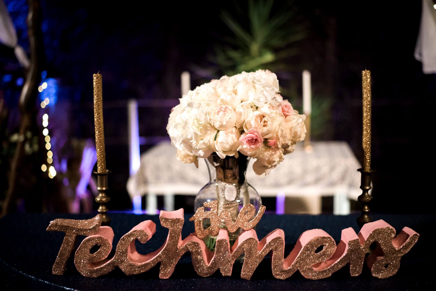 Key West Wedding Photographer captures a table with a vase of flowers and a sign that says techies.