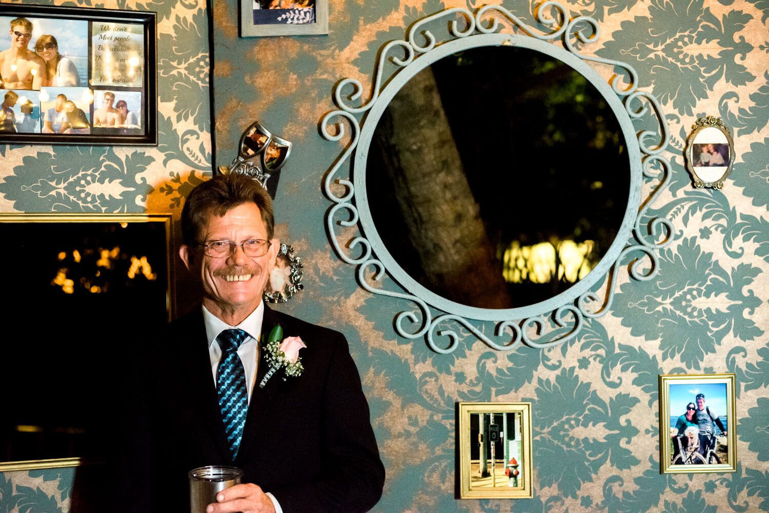 Key West Wedding Photographer captures a man in a suit standing in front of a mirror.