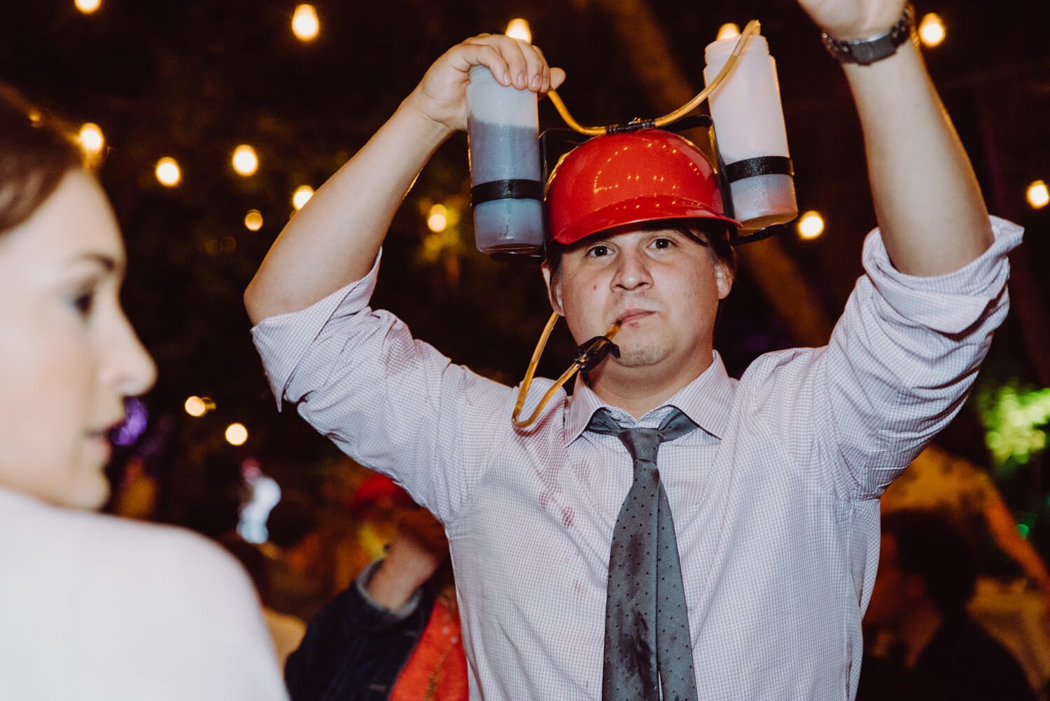 A man wearing a red hat at a party.