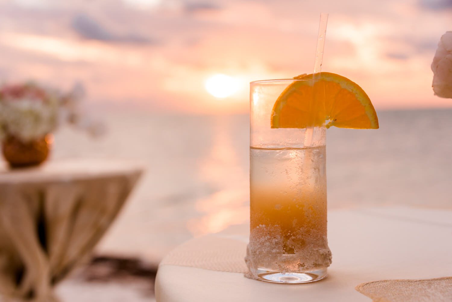 A cocktail with an orange slice on a table at a Little Palm Island wedding.