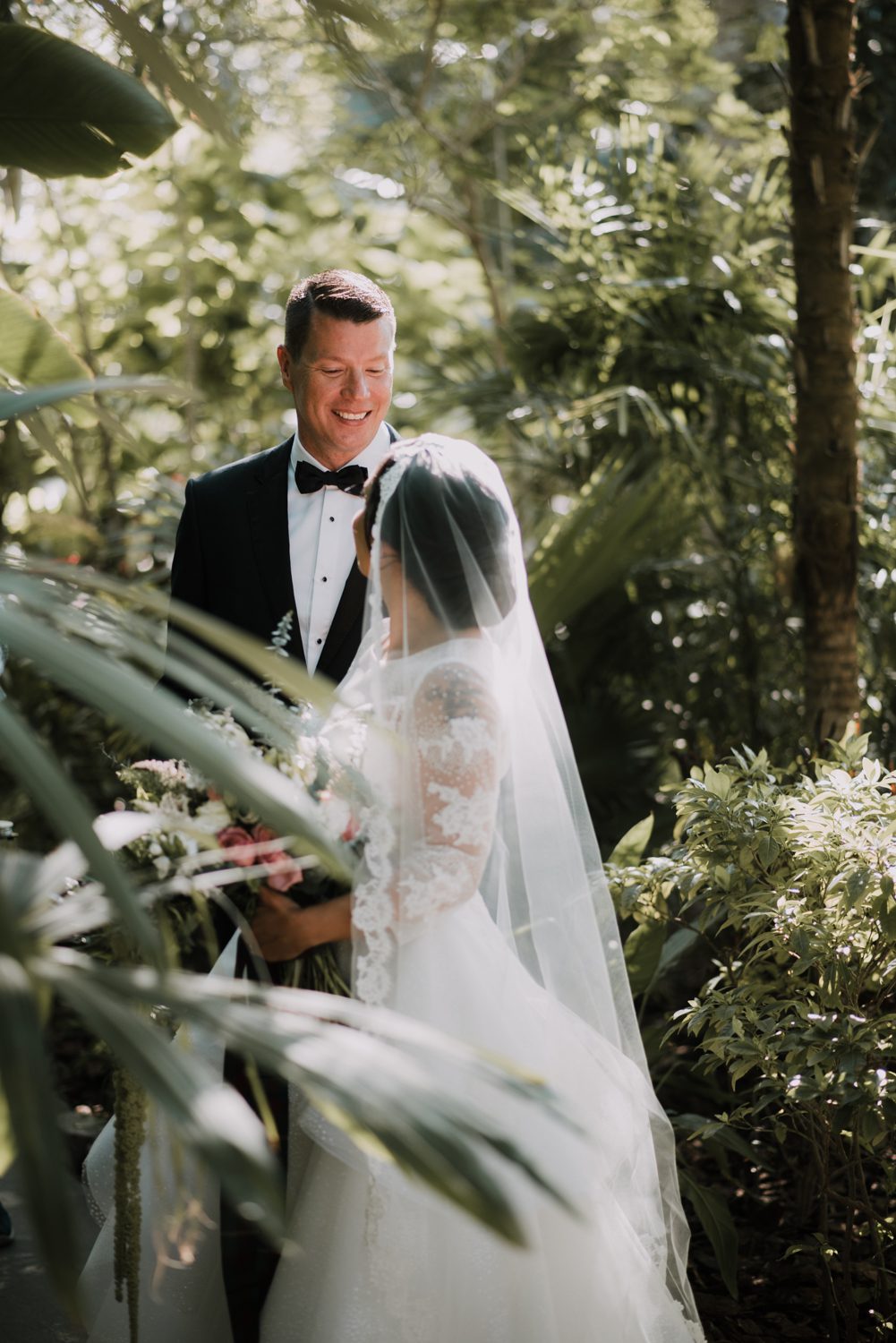 Bride and groom exchanging vows under the lush foliage at Hemingway House, a popular wedding venue in Key West