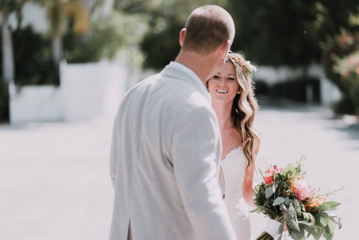 A couple of newlyweds, Kristina and Forrest, smiling while walking down the street in Key West as captured by a Fort Zachary Taylor wedding photographer.