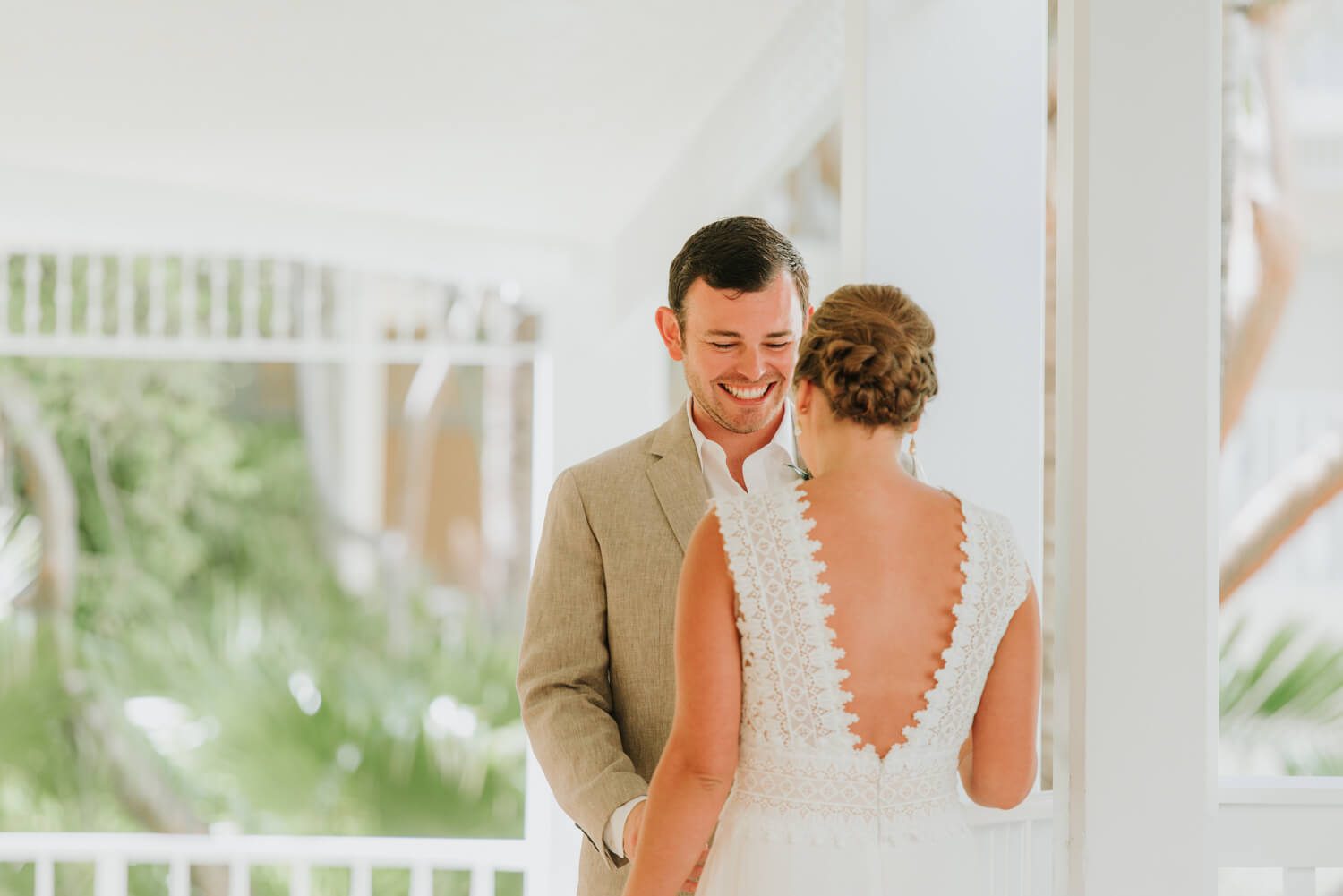A bride and groom embracing on the porch overlooking the ocean at Ocean Key Resort Spa Wedding in Key West.