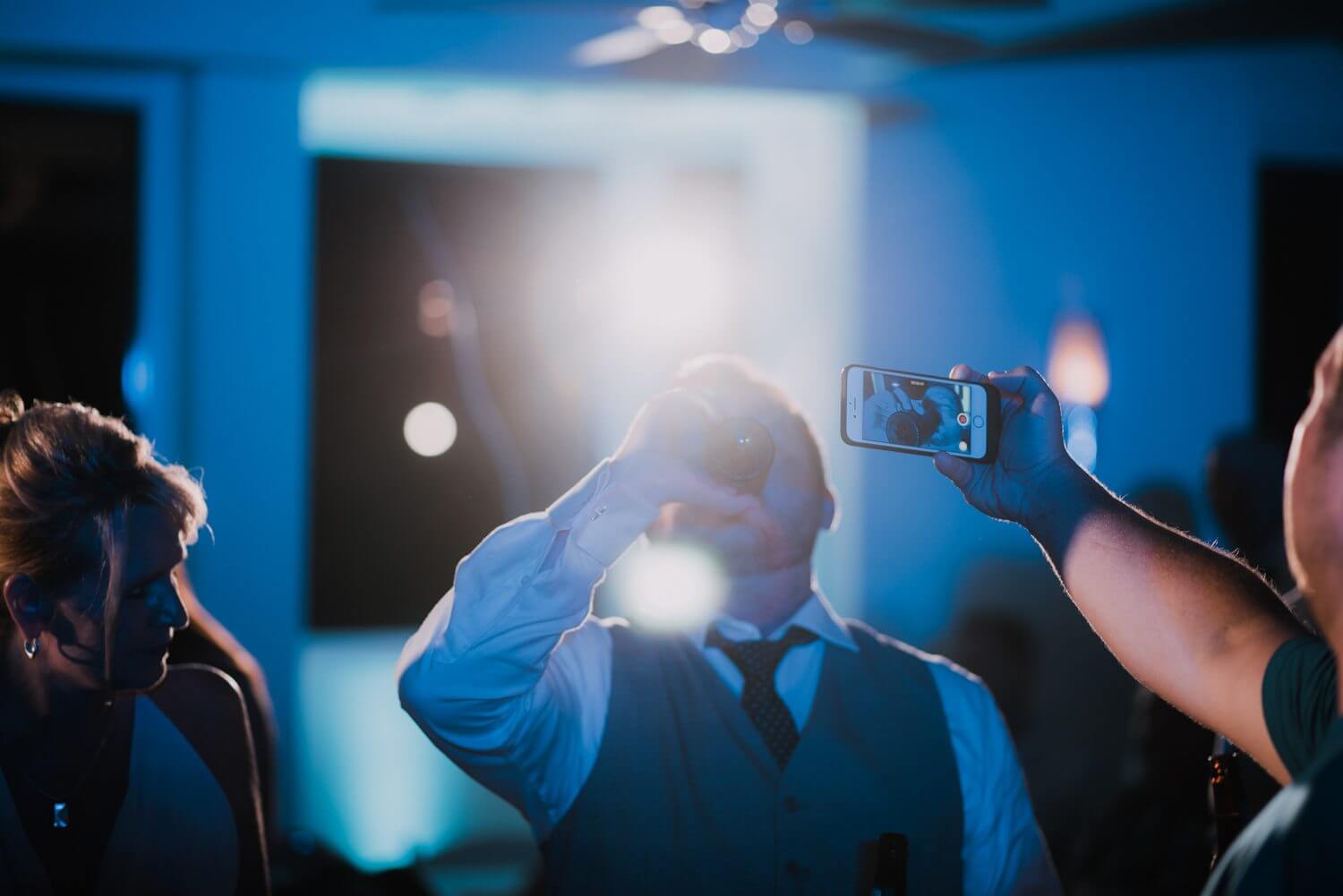 A man is taking a picture of a man at a Key West wedding reception.