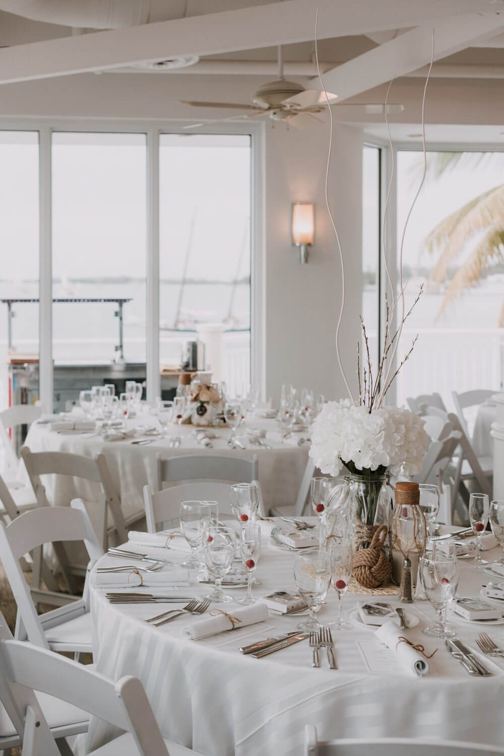 A white table set up for a Key West wedding reception.