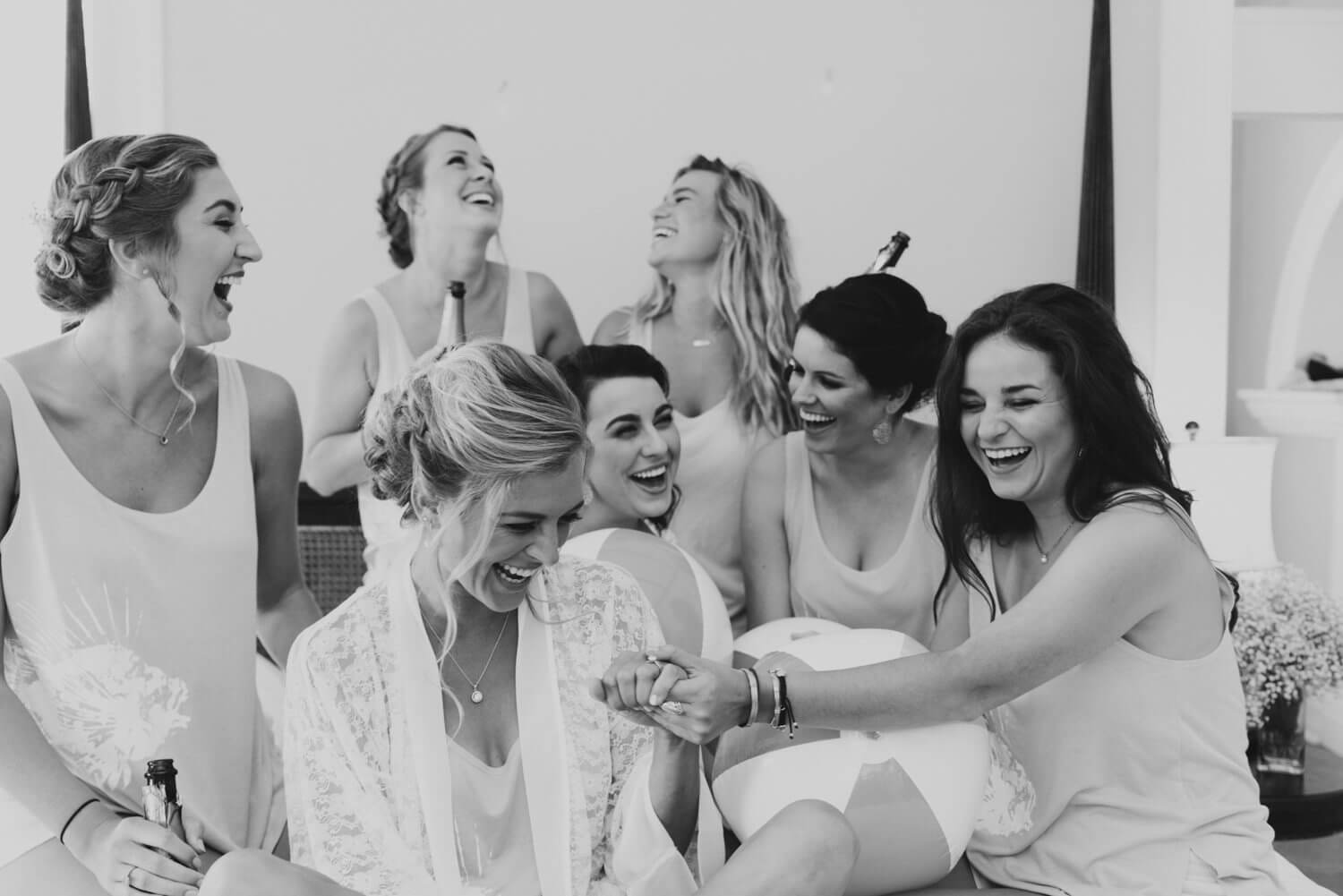 A black and white photo of bridesmaids laughing at a Key West wedding in the Southernmost Mansion.