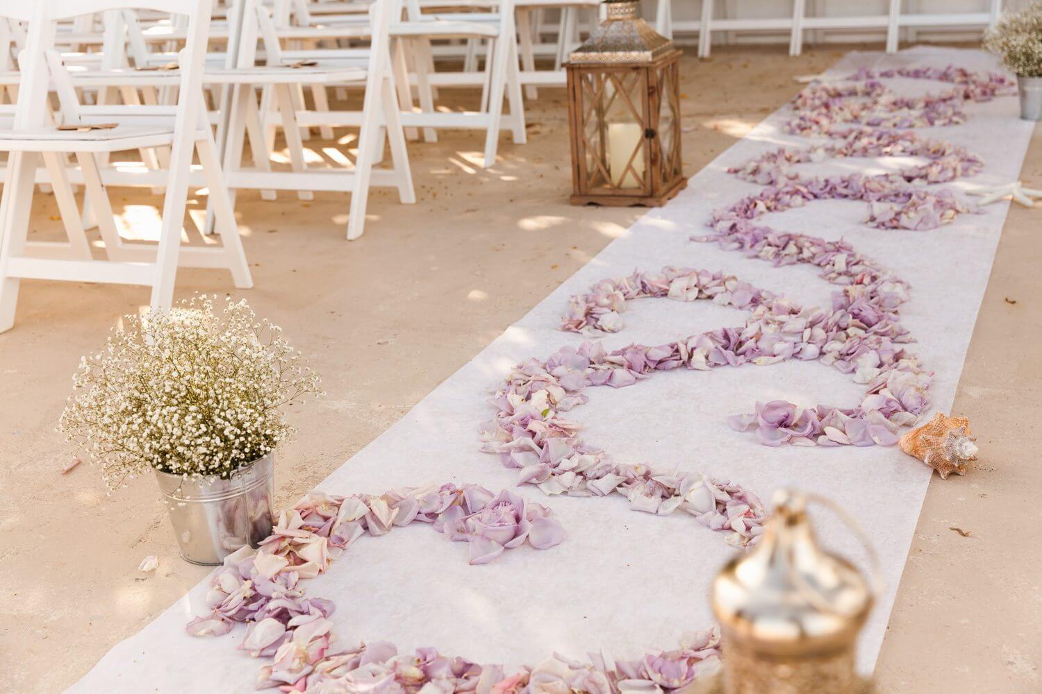 A Key West wedding aisle adorned with a charming combination of seashells and flowers, creating a captivating ambiance at the Southernmost Mansion.