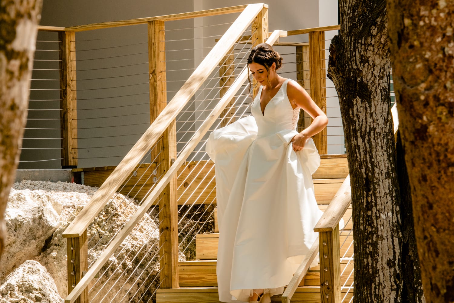 A bride is gracefully descending the stairs at her Bakers Cay Resort wedding, adorned in her exquisite wedding dress.