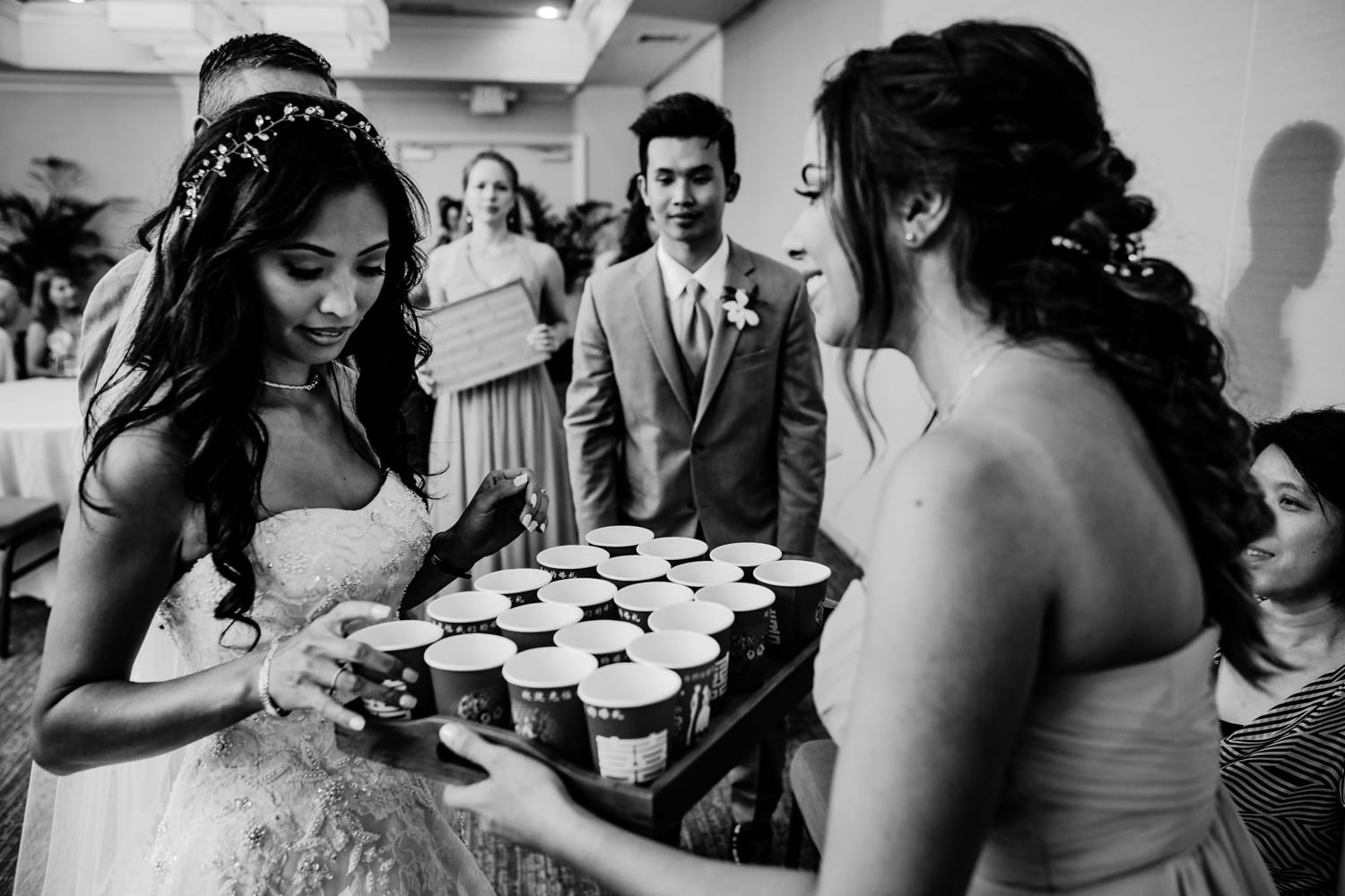 A bride is handing a tray of coffee to her bridesmaids.