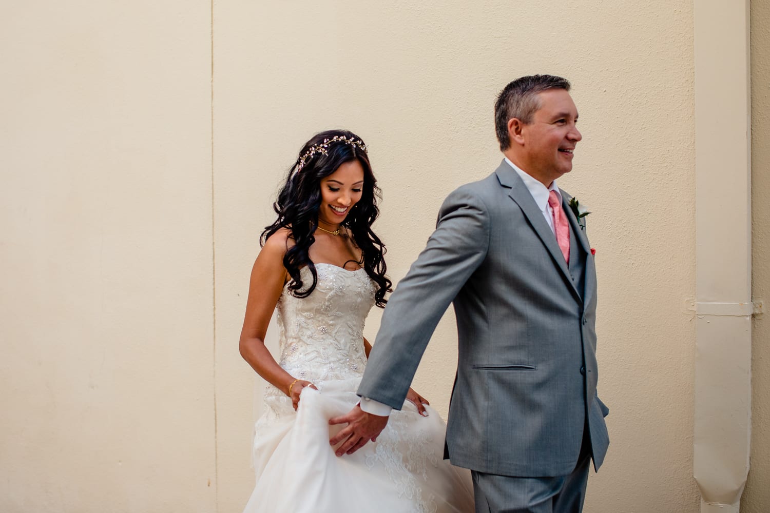 A bride and groom holding hands in front of a building.