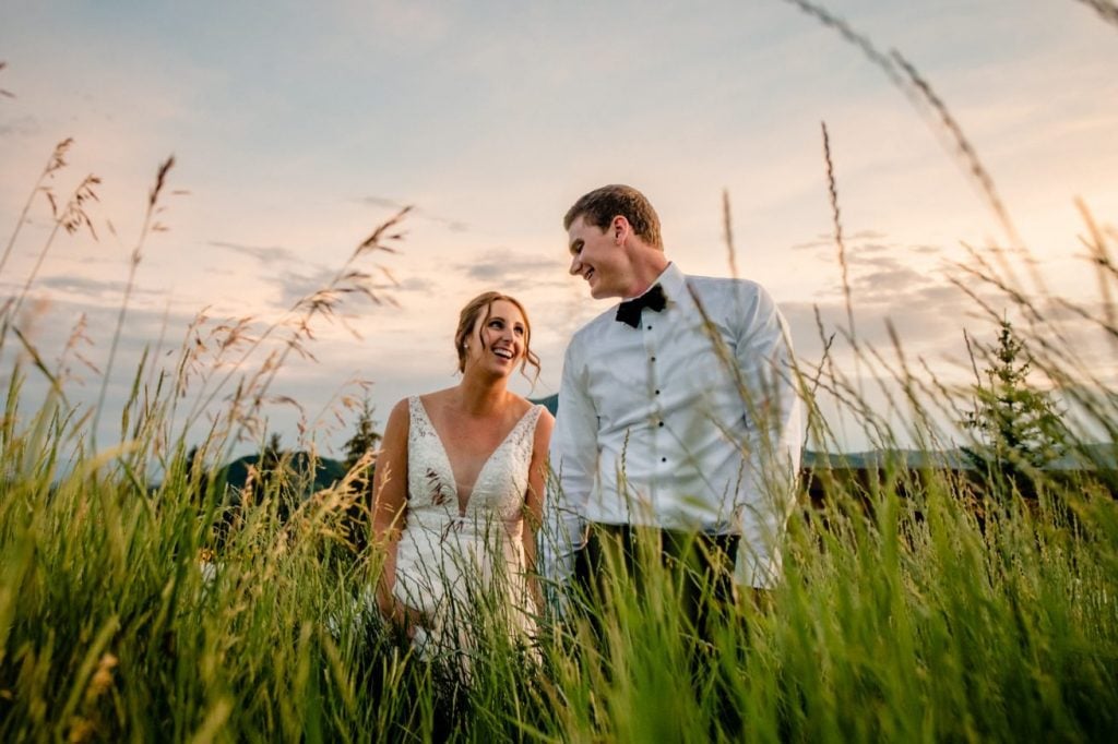 A Steamboat Springs wedding couple standing in tall grass at sunset.