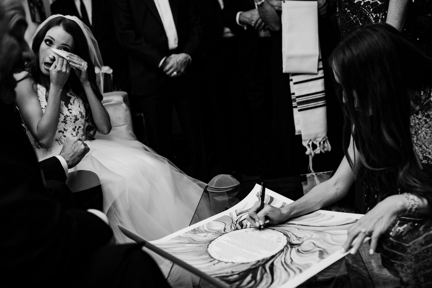 A bride signing her wedding vows in front of a group of people.