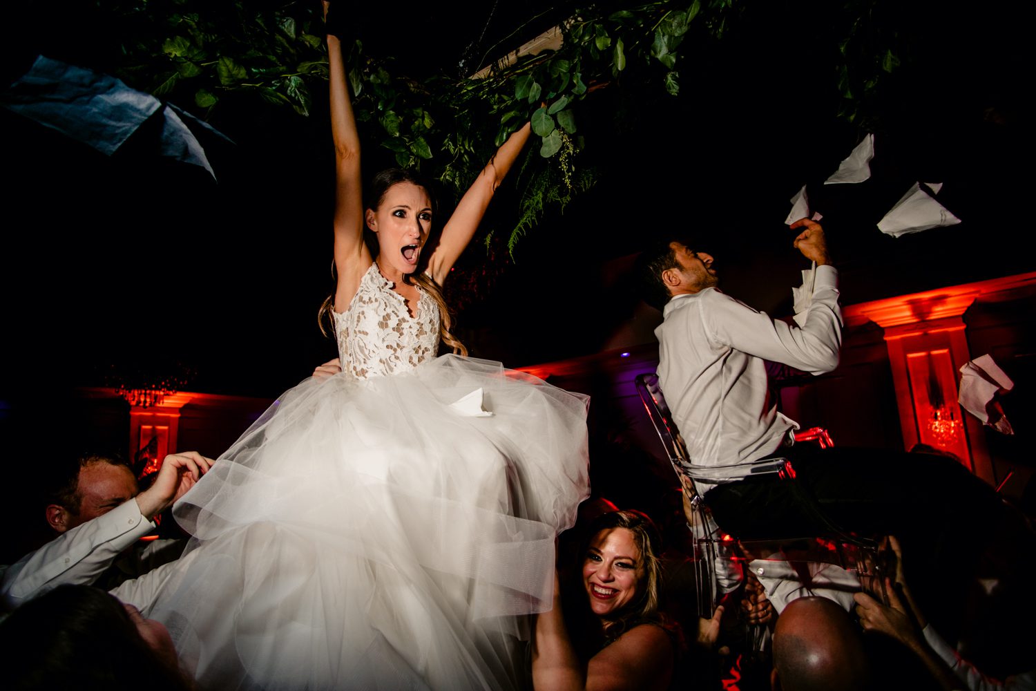 A bride and groom in a wedding dress being thrown into the air.