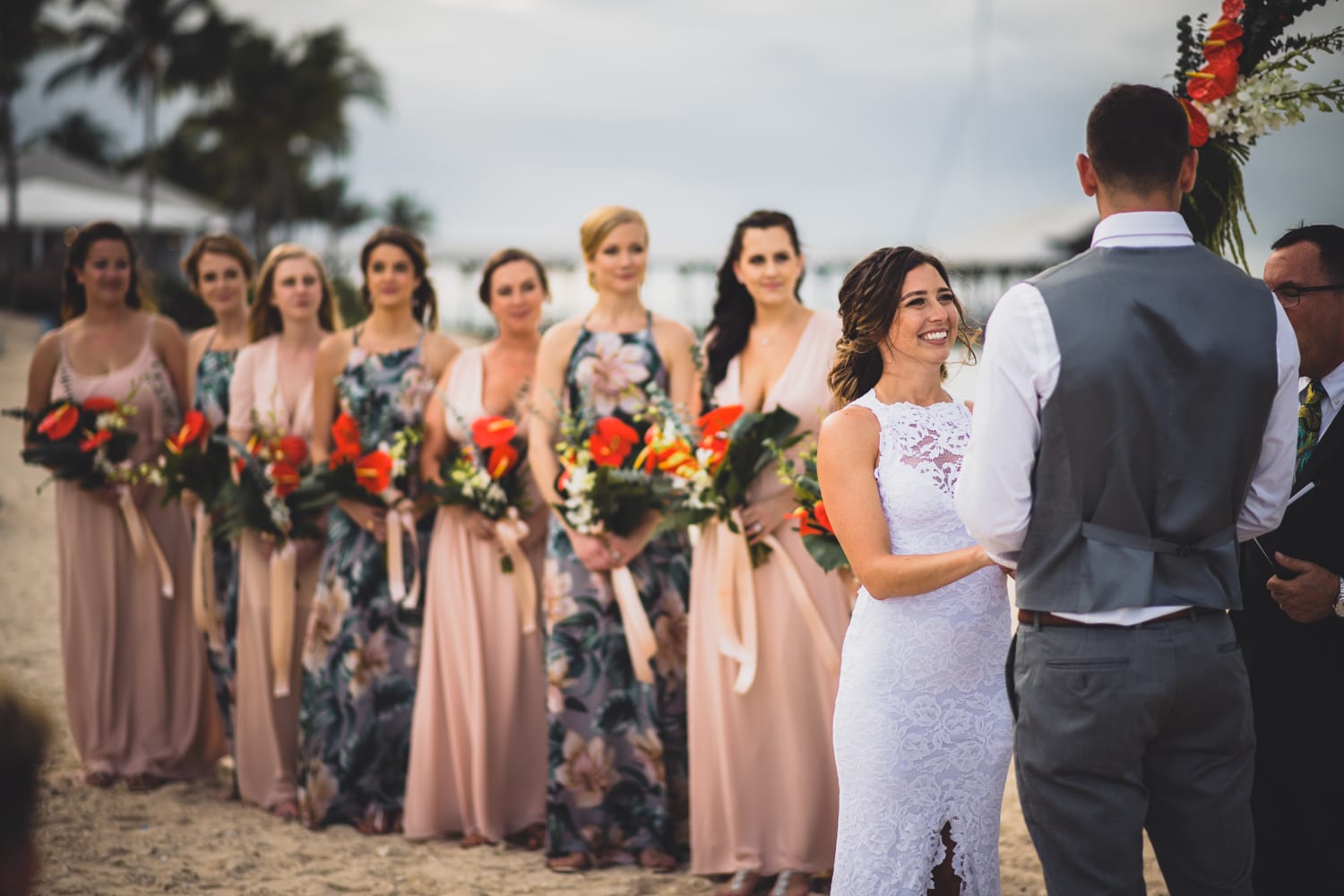 A wedding ceremony on the beach with bridesmaids and groomsmen.