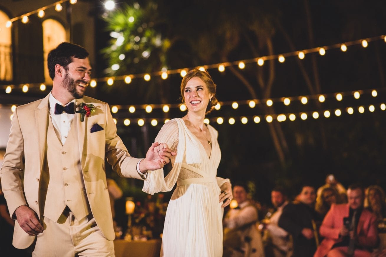 A couple walking under string lights at their Florida Keys wedding reception.