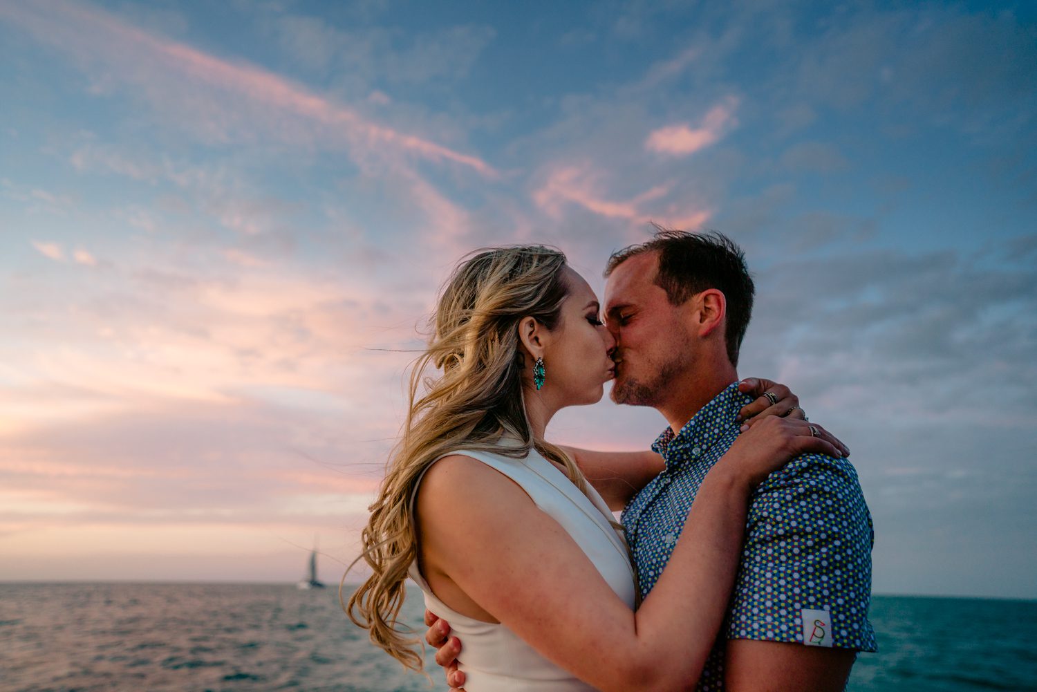 A couple kissing on a boat at sunset during their Key West wedding.