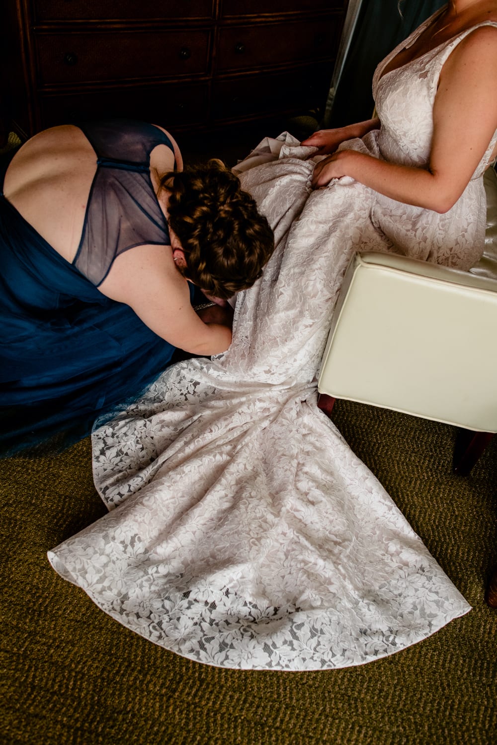 A bride is helping her bridesmaid put on her wedding dress at Fort Zachary Taylor.