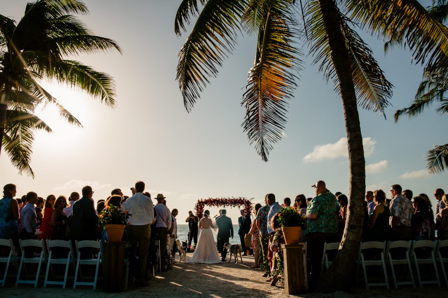 A Fort Zachary Taylor beach wedding ceremony with palm trees in the background.