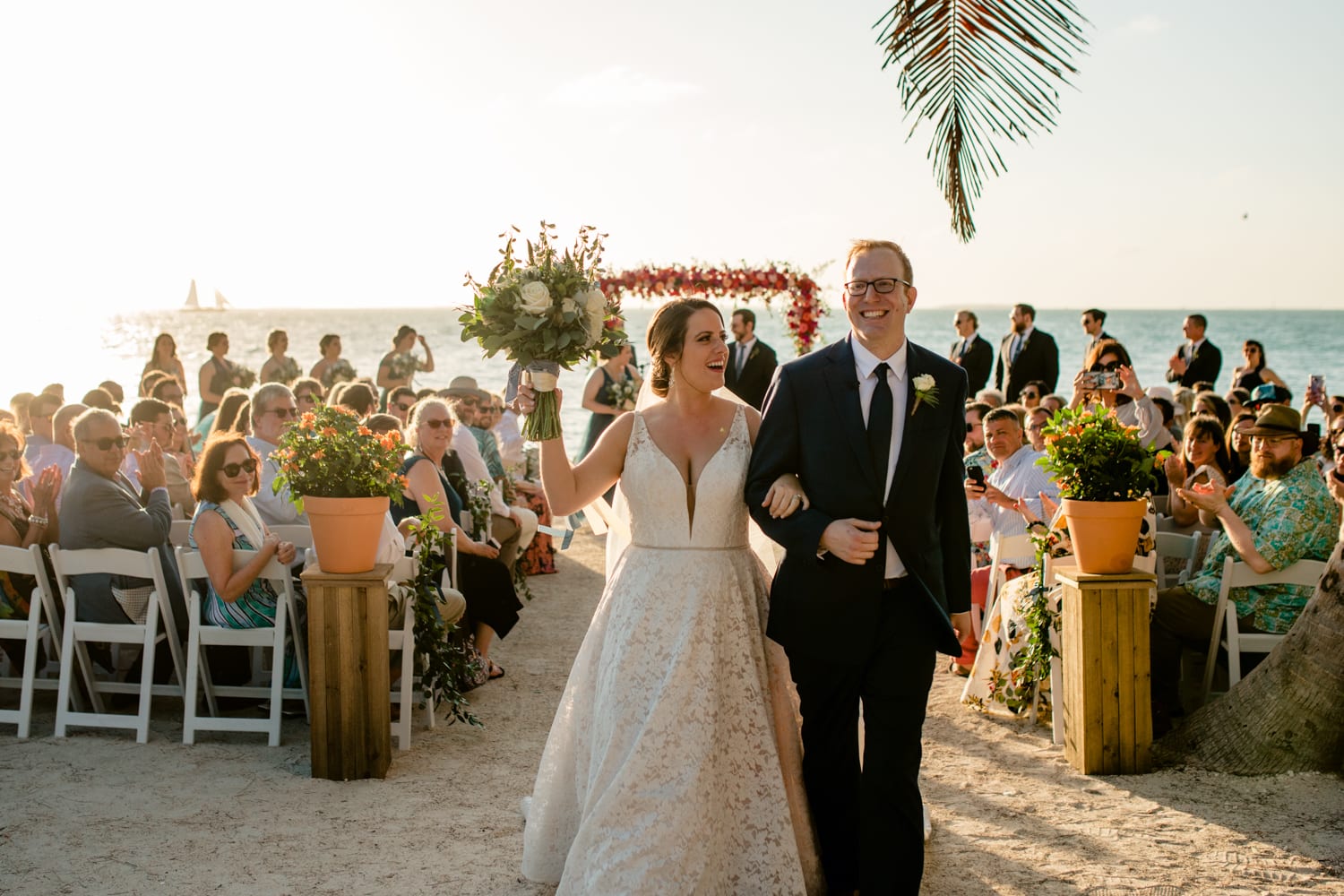 A bride and groom walking down the aisle at a beach wedding at Fort Zachary Taylor.