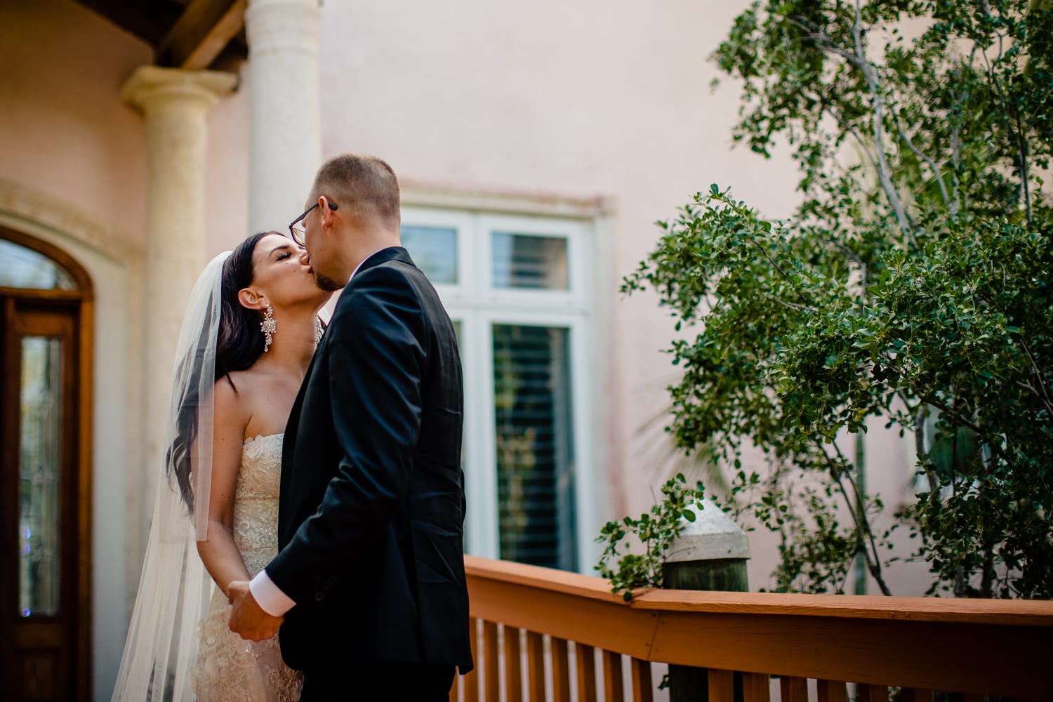 A Hemingway-inspired couple embraces on the porch of their home on their wedding day.