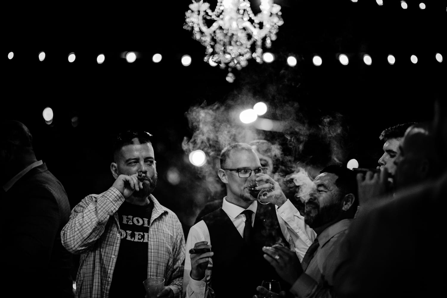 A black and white photo of men smoking at a wedding at Hemingway Home.