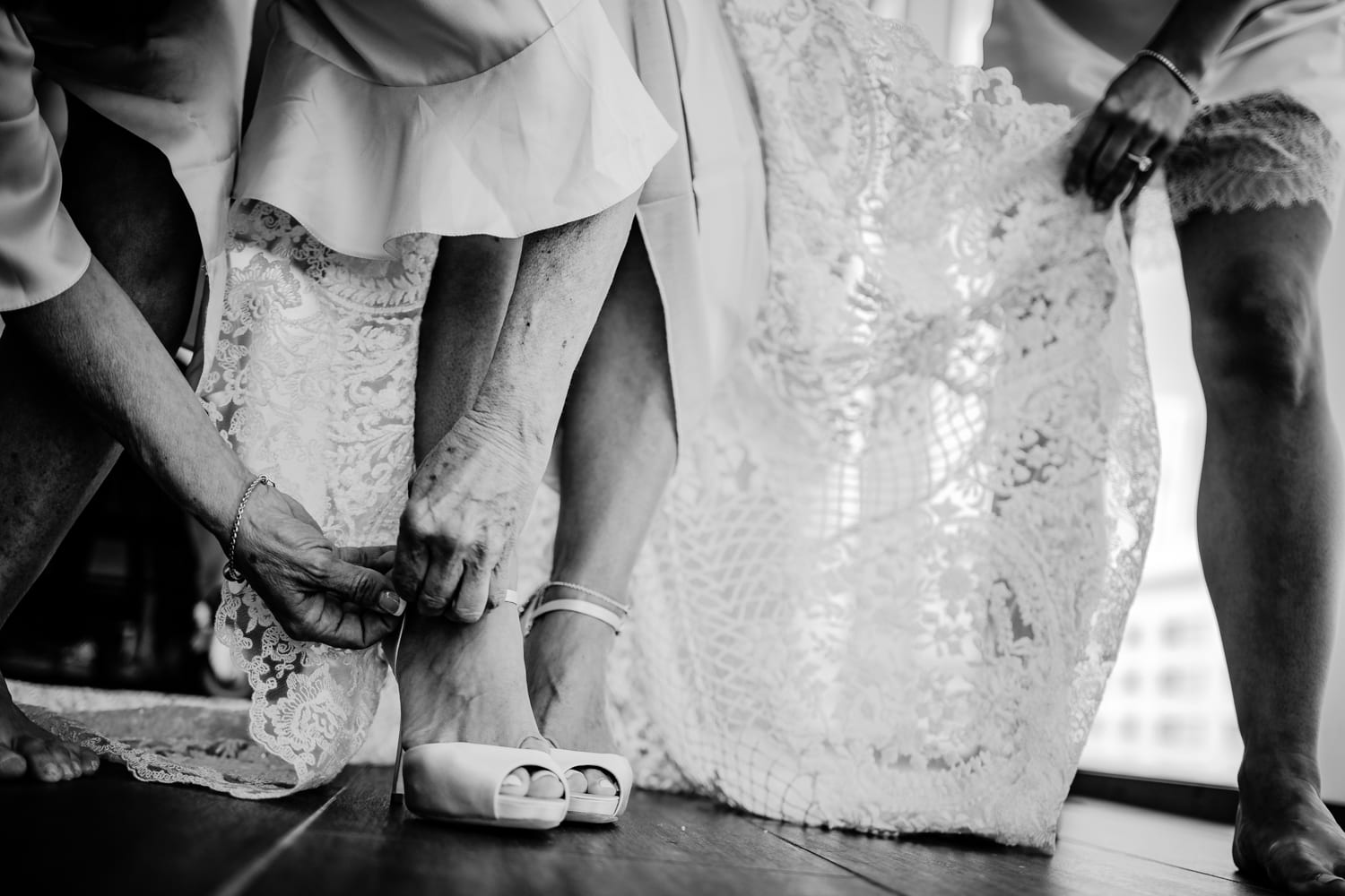 A bride is putting on her wedding shoes at Eden Roc Resort Miami.