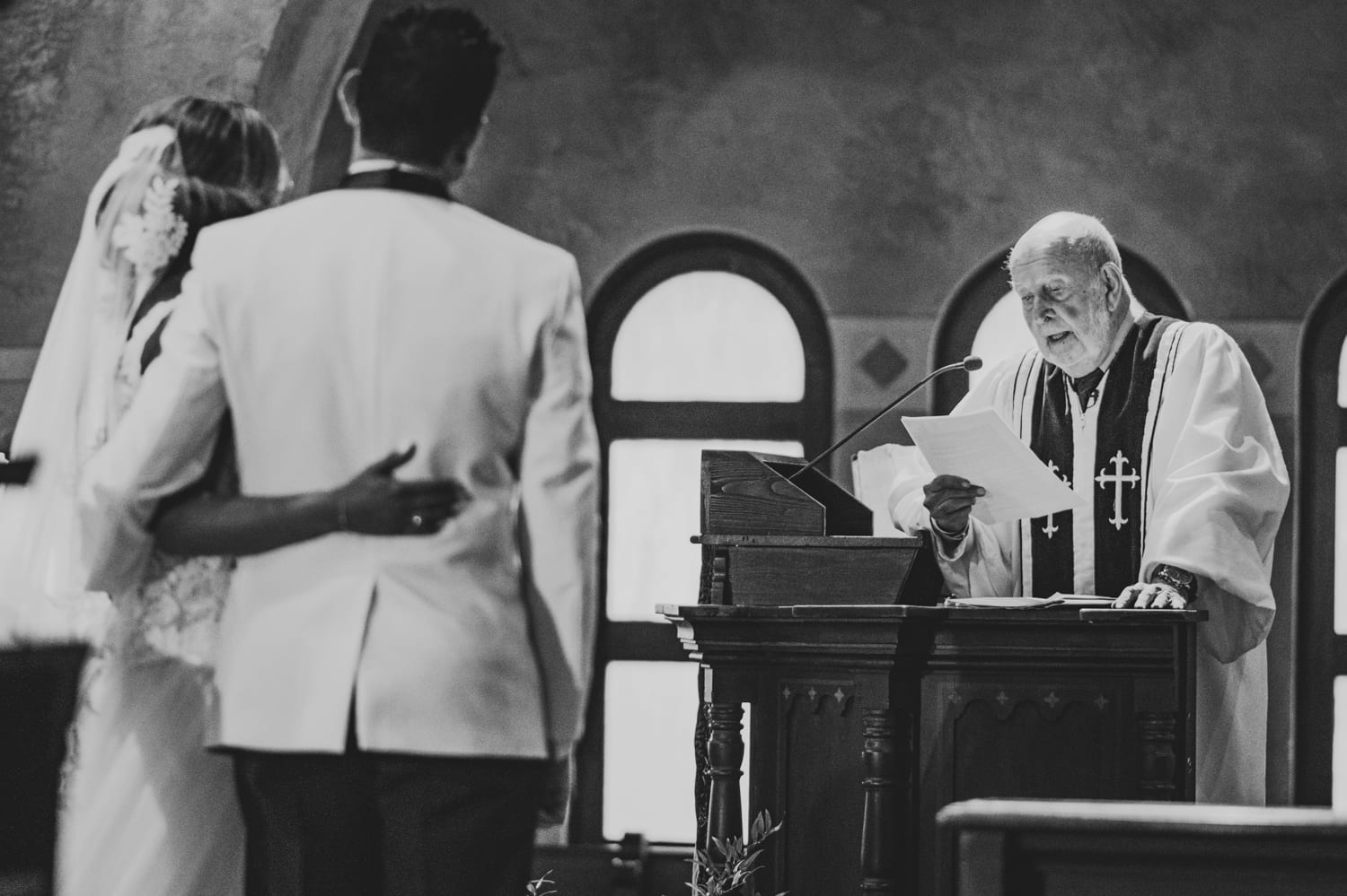 A priest officiates a coral gables wedding ceremony.