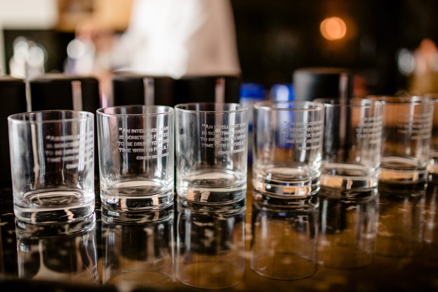 A row of whiskey glasses lined up on a bar at a Casa Marina wedding.